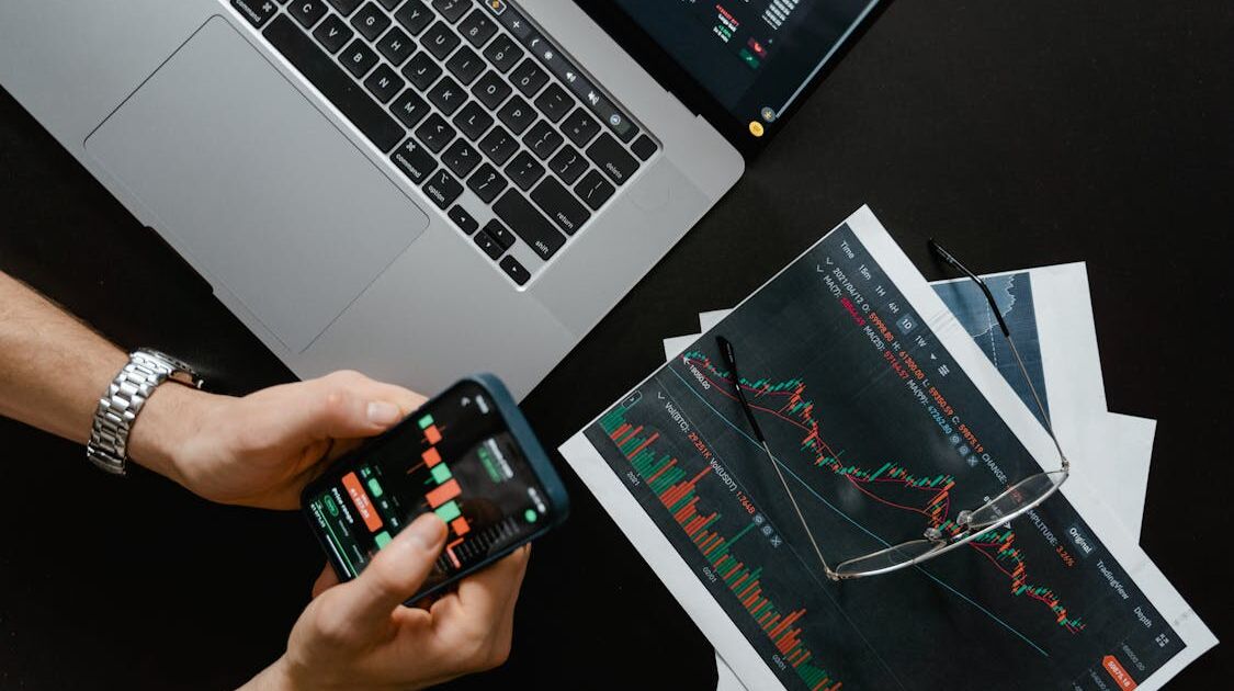 Laptop, Smartphone und Diagramme, Symbol für Datenströme und Kontrollfragen