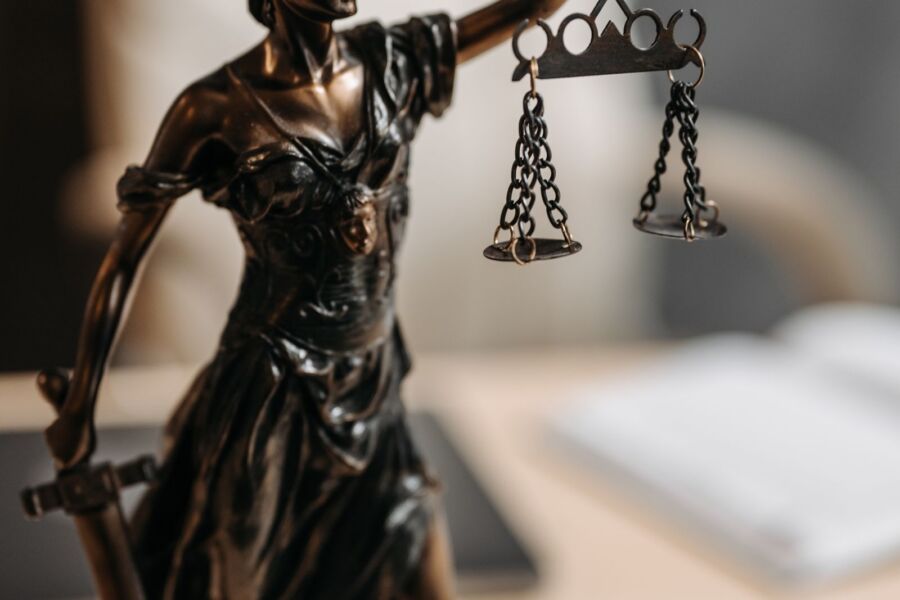 Justitia-Figur mit Waage und Schwert, Symbolbild für gerichtliche Prüfung
